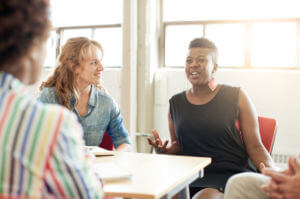 Candid picture of a business team collaborating. Filtered series with light flares, bokeh and warm sunny tones.